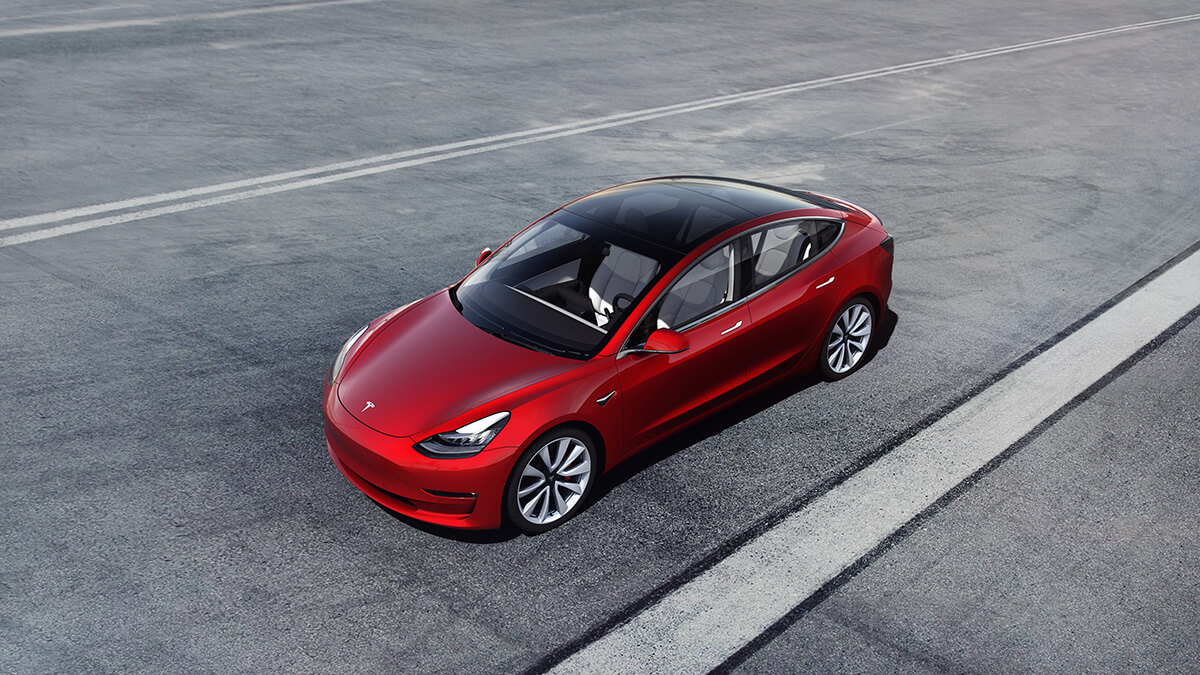 Tesla Model 3 en rouge, sur une piste de course